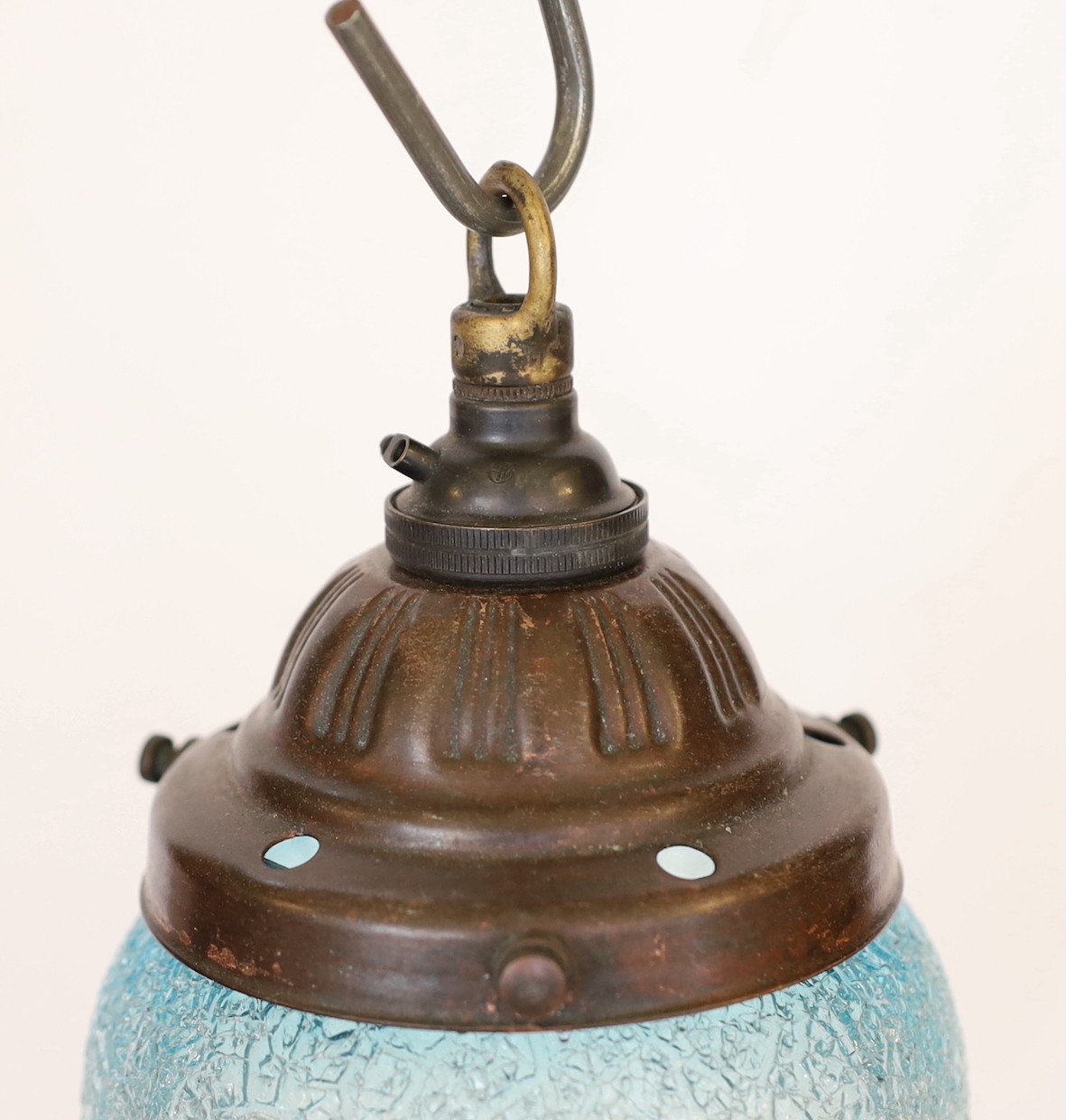 A 1920's English bronzed metal light pendant with blue tinted frosted glass shade, height 22cm